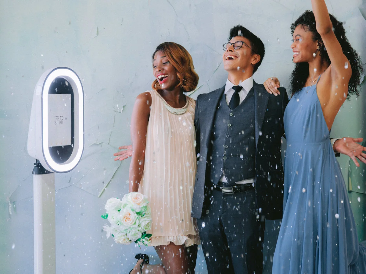 Friends celebrating with confetti beside the Salsa photo booth