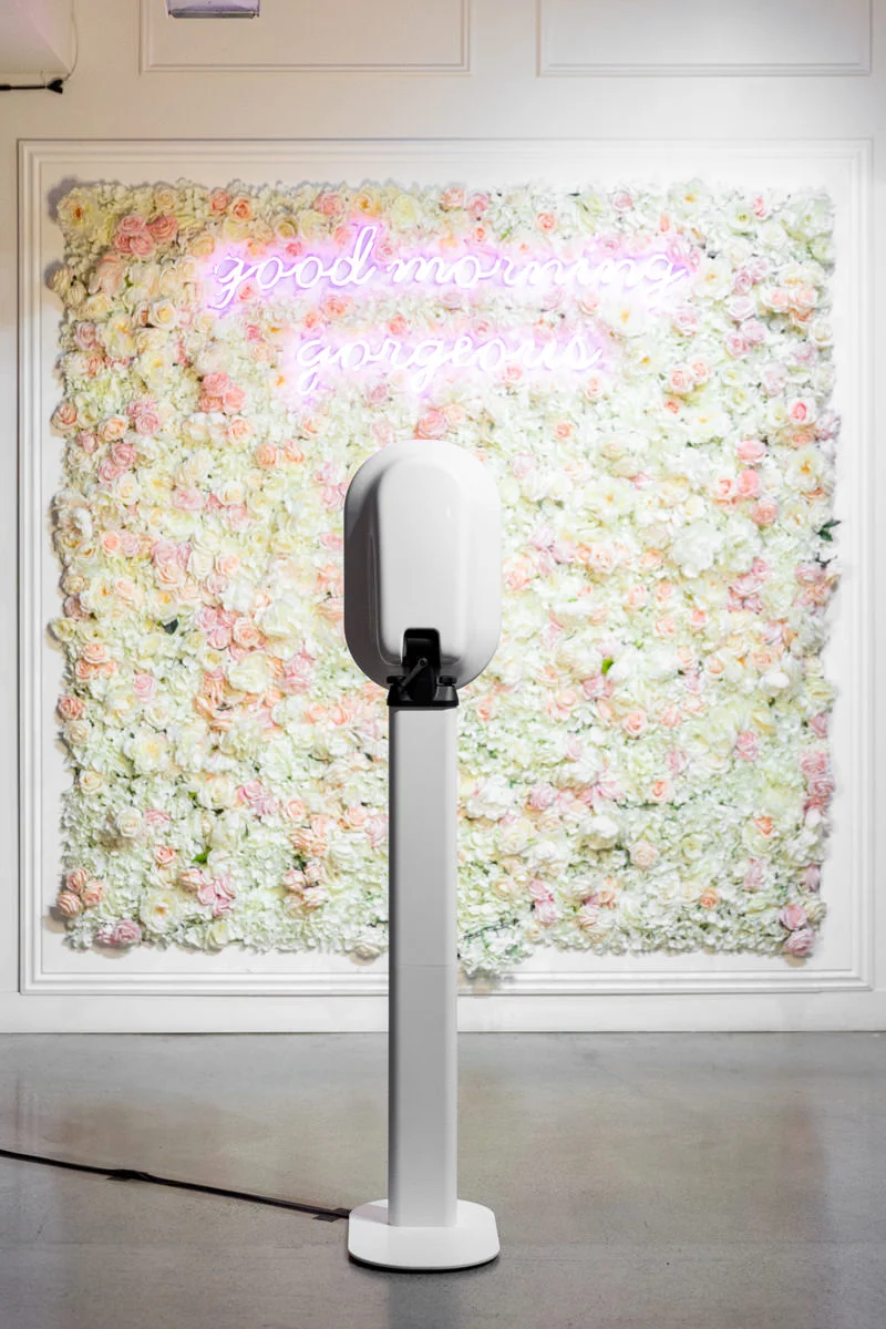 White photo booth in front of a soft floral backdrop