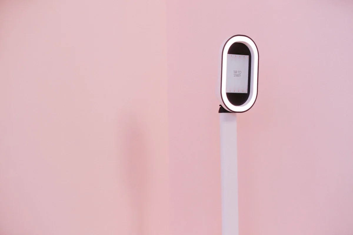 White open-air photo booth against a blush pink studio backdrop